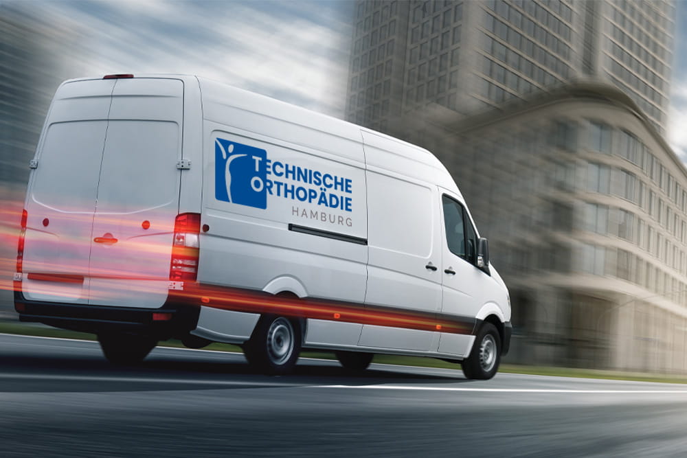 A white van with the logo of the Technical Orthopaedics Hamburg drives quickly through the city.