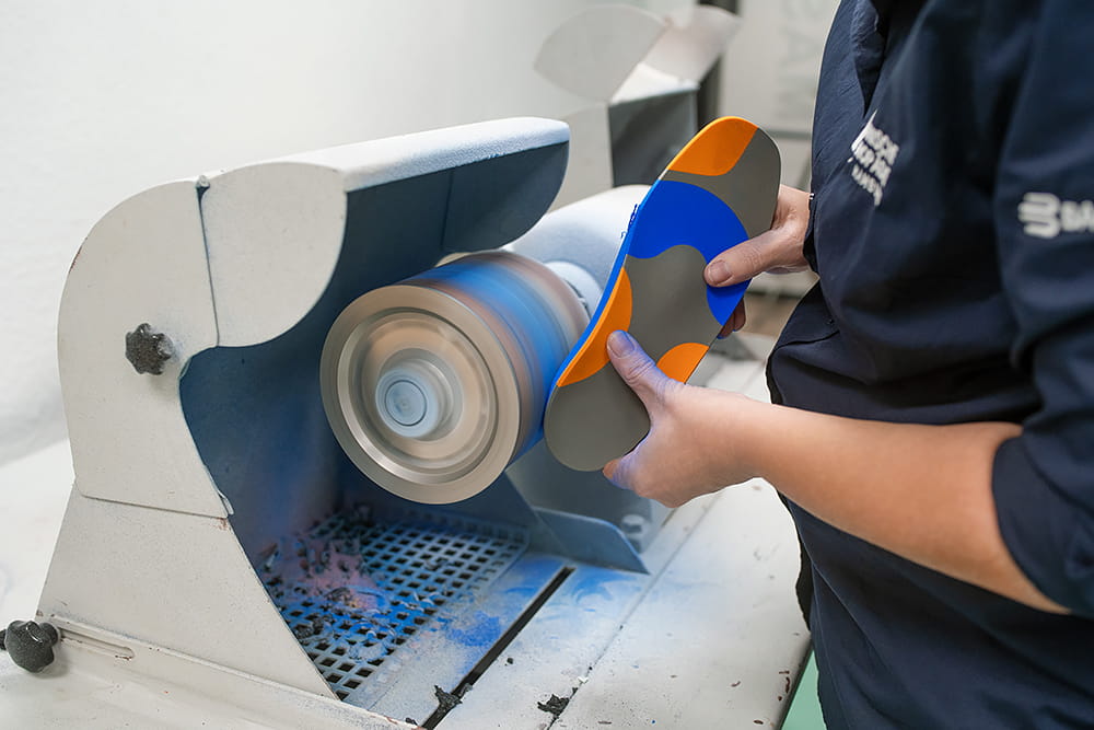 Schleifen einer bunten Einlage an einer Schleifmaschine.