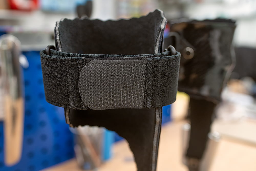 Eine Nahaufnahme des schwarzen Klettverschlusses einer Beinorthese.