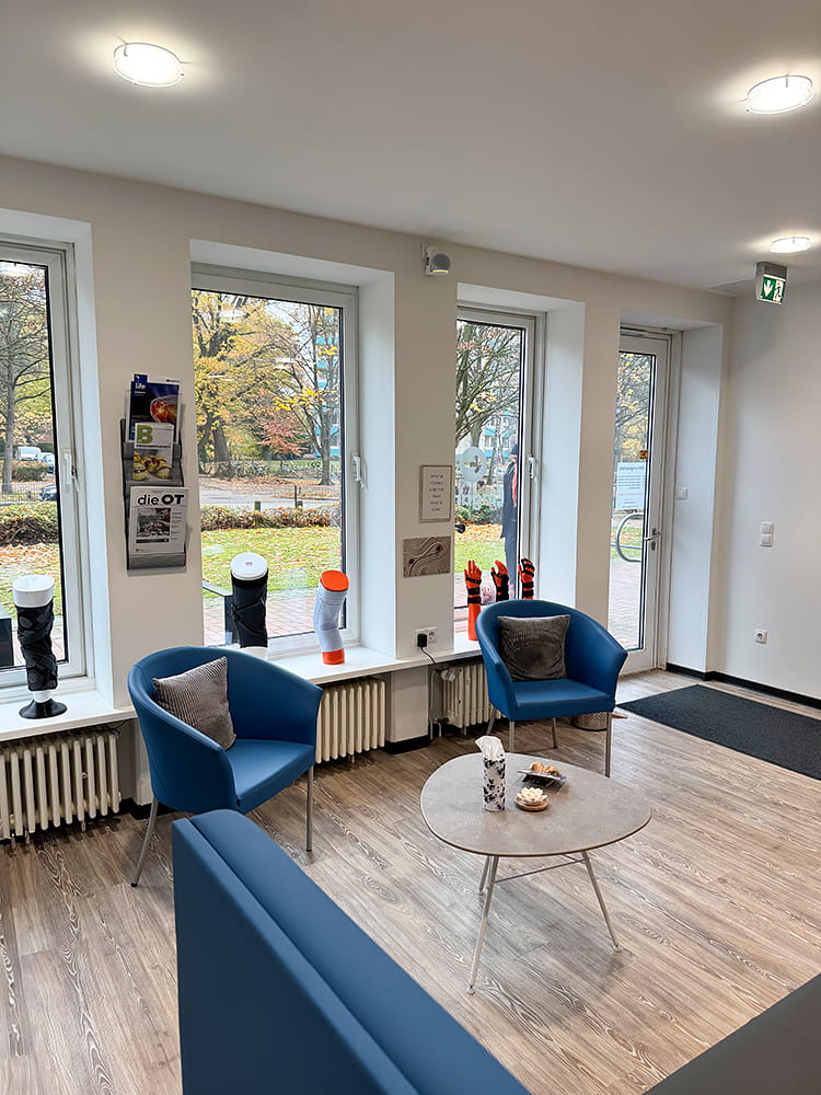 Der Wartebereich des Sanitätshauses in Hamburg mit blauen Stühlen und eine bequemen Couch.